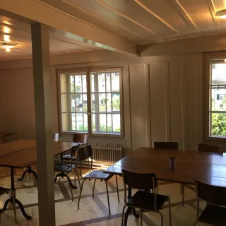 Ein Zimmer mit Tischen und Stühlen